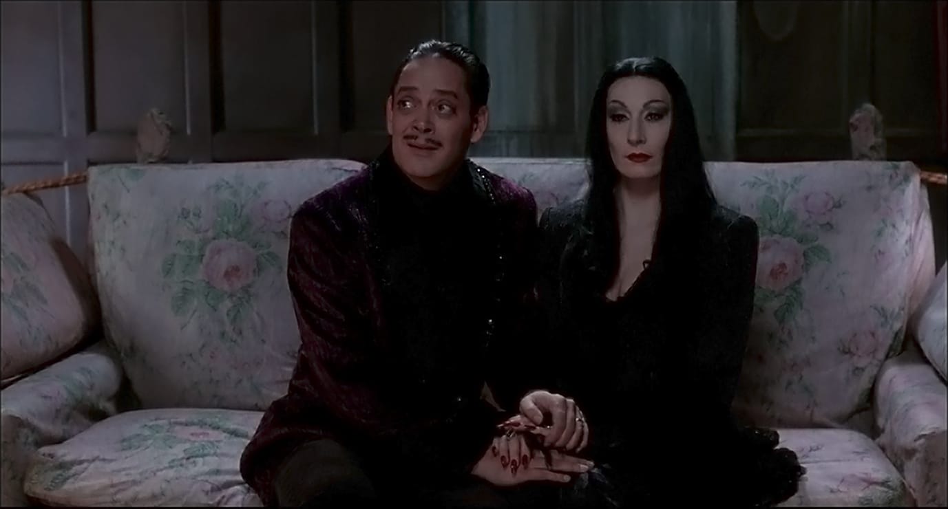 Raul Julia and Anjelica Huston